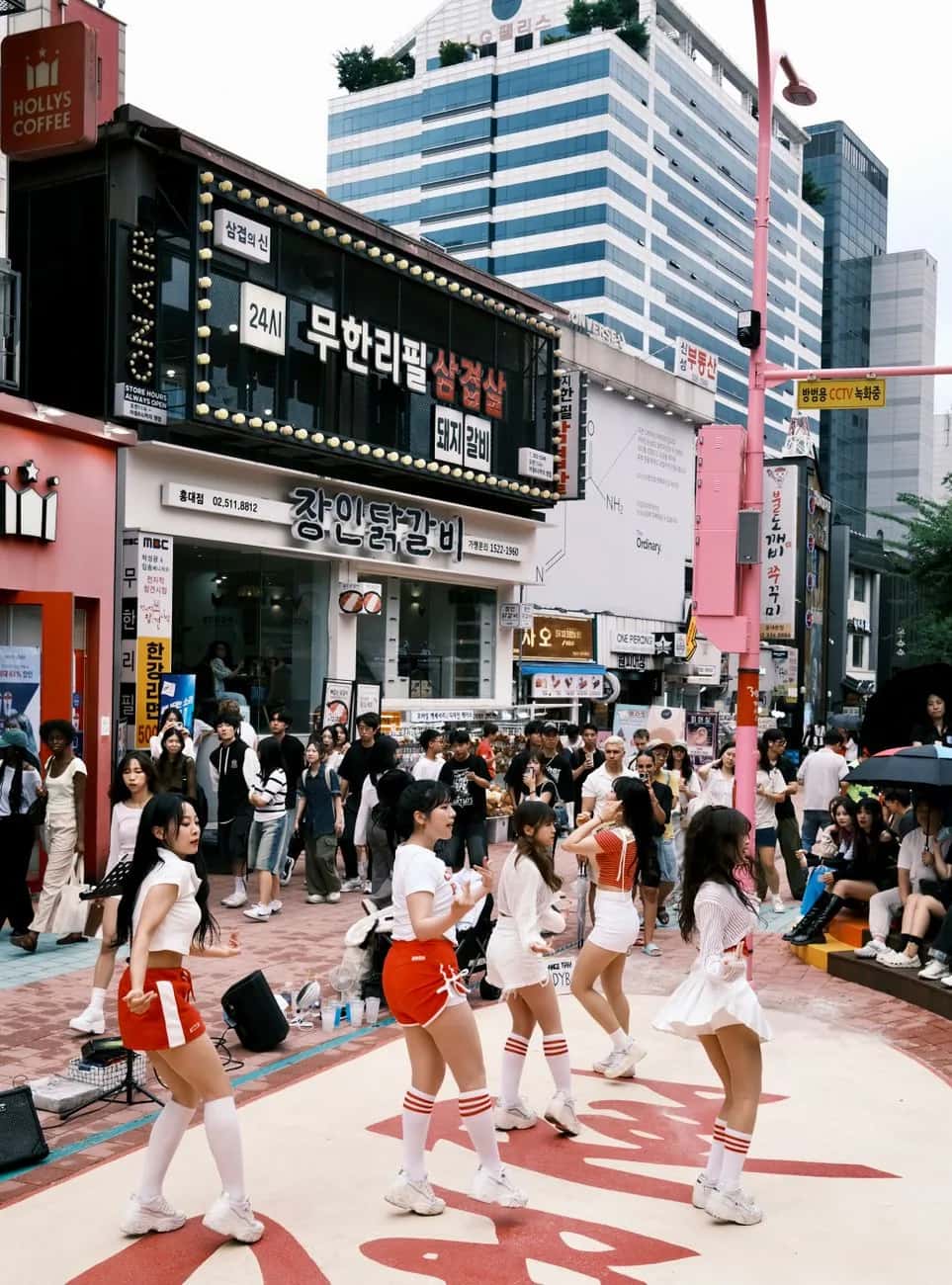 Groupe de danse de reprise K-pop en pleine performance dans une rue du quartier de Hongdae, à Séoul